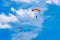 A parachutist against a background of blue sky and white clouds. Skydiving