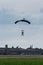 Parachutist with Blue Parachute near to the Ground Preparing for Landing