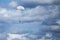 Parachutist descending from above with a white canopy