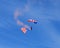 Parachutist descending with the American flag and red smoke attached to his legs