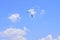 Parachutist descends into the blue sky on a sunny day