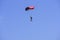 Parachutist descends into the blue sky on a sunny day