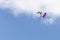 The parachutist descends from the sky with a state symbol, against the blue sky.