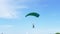 Parachutist Flies on a Paraglider in Blue Sky and Lands on Green Grass. 4K