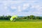 The parachutist has landed on a grassy field. Skydiving