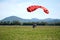 Parachutist jumped from an airplane uses a parachute to land.