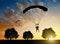 Parachutist landing at sunset