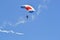 The parachutist with a multi-colored parachute flies in the sky.