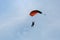 Parachutist with Orange Parachute against Clear Blue Sky