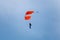 Parachutist with Orange Parachute against Clear Blue Sky