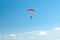 Parachutist soar on colorful parachutes across the boundless blue sky against the background of white fluffy clouds