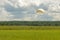 Parachutist before touchdown in a field of grass