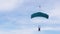 Parachutists Flies on a Paraglider in Blue Sky and Lands on Green Grass. 4K