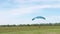 Parachutists Flies on a Paraglider in Blue Sky and Lands on Green Grass. 4K