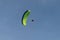 Parachutists: Instructor and Beginner with Green Parachute against Clear Blue Sky