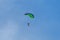 Parachutists: Instructor and Beginner with Green Parachute against Clear Blue Sky