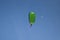 Parachutists: Instructor and Beginner with Green Parachute against Clear Blue Sky