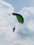 Parachutists: Instructor and Beginner with Green Parachute against Clear Blue Sky