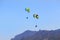 Parachutists on paragliders fly over the mountains