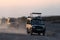 Parade of Toyota Land Cruiser safari vehicles proceeed to leave Amboseli National Park at dusk