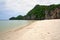 Paradise beach with white sand and rocky limestone cliff