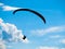 Paraglide silhouette with blue sky and white clouds