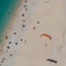 Paraglider above people enjoy the sun on the beach, Myrtos beach Kefalonia Greece