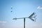 Paraglider and arrow shape weathervane against summer`s sky with cumulus in background, italian Alps. Italy