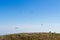 Paraglider on blue sky with empty bench on foreground