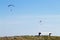 Paraglider on blue sky with empty bench on foreground