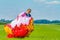 Paraglider carrying mattress flyer in green pasture