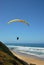 A paraglider cruising along the beach