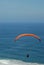 A paraglider cruising along the beach