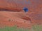 Paraglider drops to the ground along a canyon in Arches National Park.
