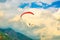 A paraglider flies high in the mountains against the background of an epic sky