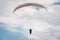 A paraglider flies in the sky in a cocoon suit on a paraglider against the sky and clouds. Paragliding Sport Concept