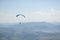 Paraglider flies in the sky over the mountains on a bright sunny day. Paragliding in the sky