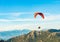Paraglider floating in the air with blue sky and mountains on background in Turkey