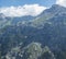 Paraglider fly over limestone mountain peaks. Kiting in blue and orange kite in Stubai valley Tirol Alps, Austria