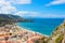 Paraglider flying above the amazing landscape of coastal city Cefalu in beautiful Sicily. Paragliding is a popular extreme sport.