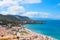 Paraglider flying above the beautiful seascape by city Cefalu in Sicily, Italy. Paragliding is a popular adventure sport.