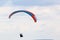 Paraglider flying in a cloudy sky