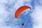 Paraglider flying orange wing