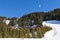 Paraglider flying over an alpine mountain resort