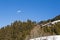 Paraglider flying over an alpine mountain resort