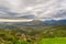 Paraglider flying over the green mountains around Cape Town, South Africa. Winter season, cloudy and dramatic sky. Unrecognizable