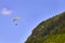 Paraglider flying over green slopes. Swiss Alps.