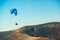 Paraglider flying over mountains in sunny day. Freedom concept. Soaring flight moment. Paragliding in the sky. Extreme sport.