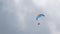 Paraglider flying in sky with clouds with parachute. Professional paragliding.