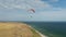 Paraglider is flying in the sky over the shoreline of the sea